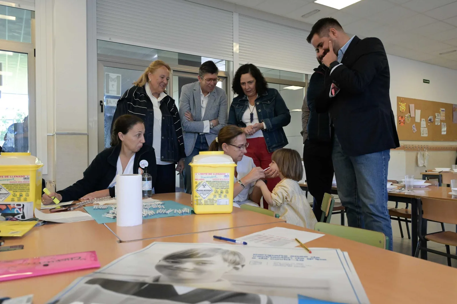 Una enfermera aplica por la nariz la vacuna de la gripe a un alumno de infantil del CEIP Vales Villamarín, mientras las autoridades de la visita observan.