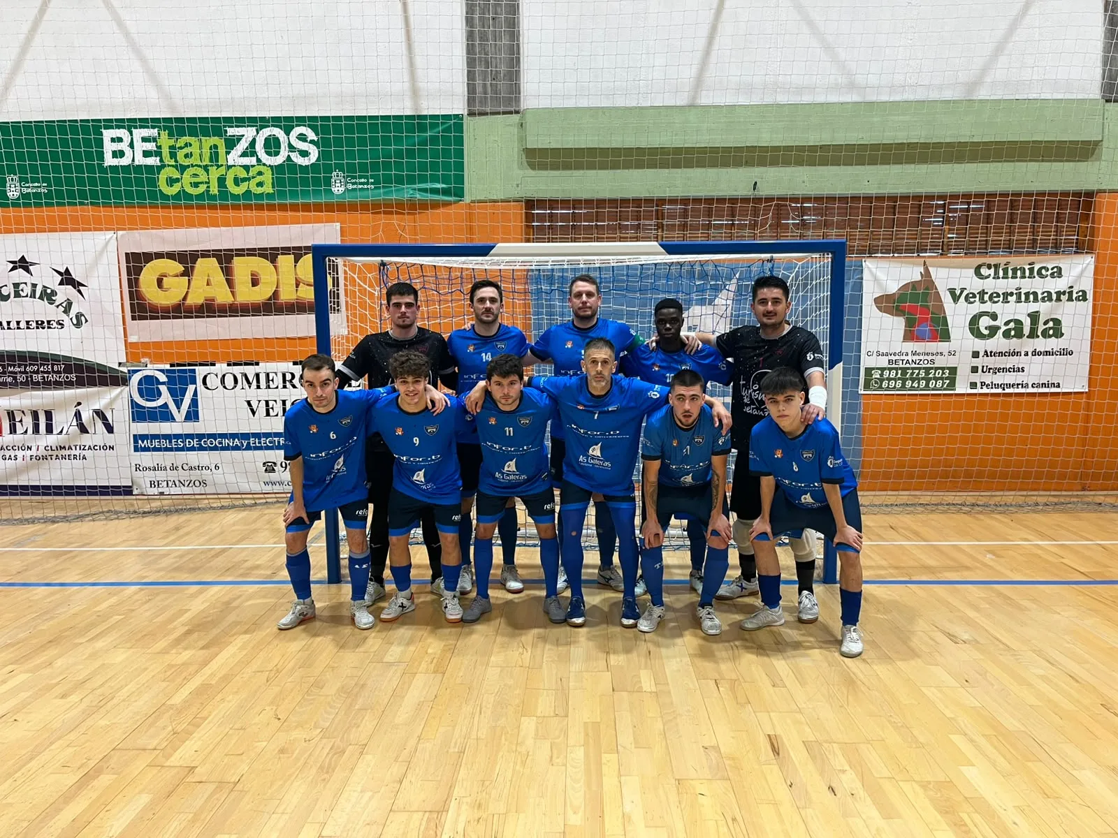 El primer equipo del Troula Betanzos FS, de azul, posa ante una portería del pabellón Tocayo de Betanzos.